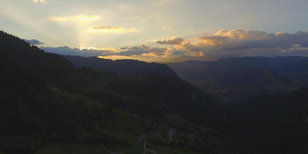 a view of a mountain valley with the sun setting at Cabane entre terre et ciel in Saint-Nicolas-la-Chapelle
