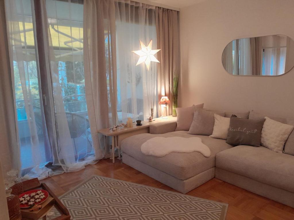 a living room with a couch and a large window at Appartment with Spa in Vienna