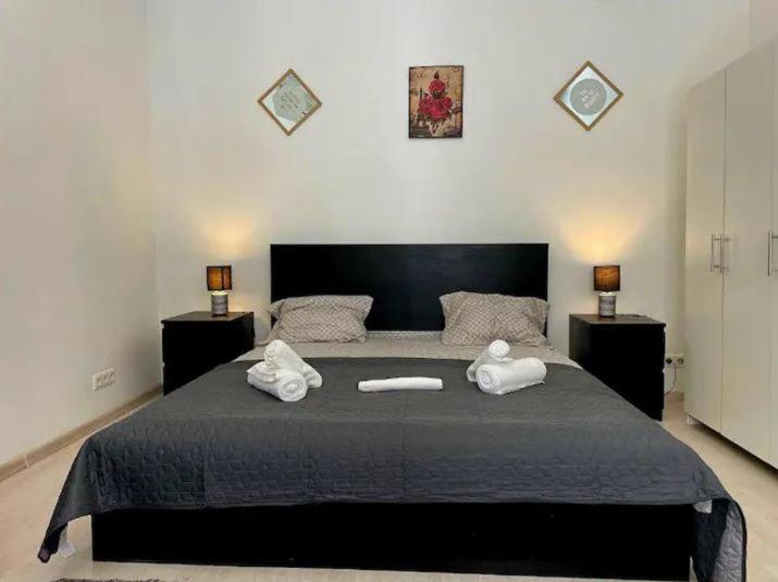 una camera da letto con un letto grande con asciugamani sopra di The Perfect Location Studio! a Bucarest