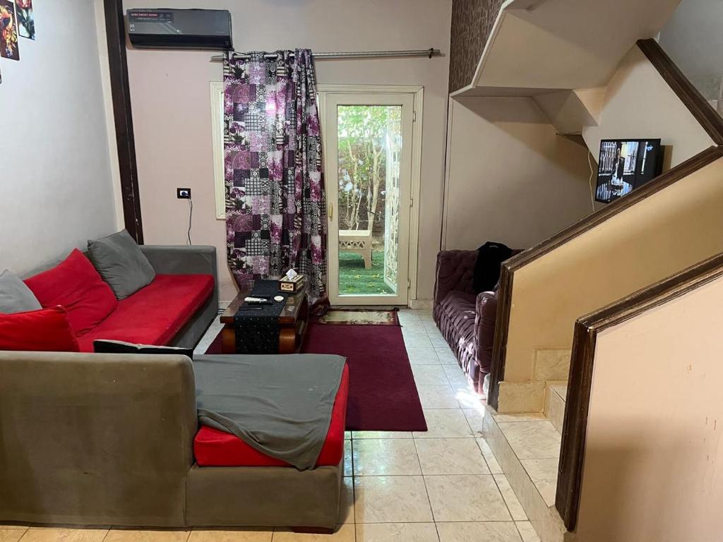 a living room with two couches and a window at Cozy Townhouse with a Backyard in Sheikh Zayed
