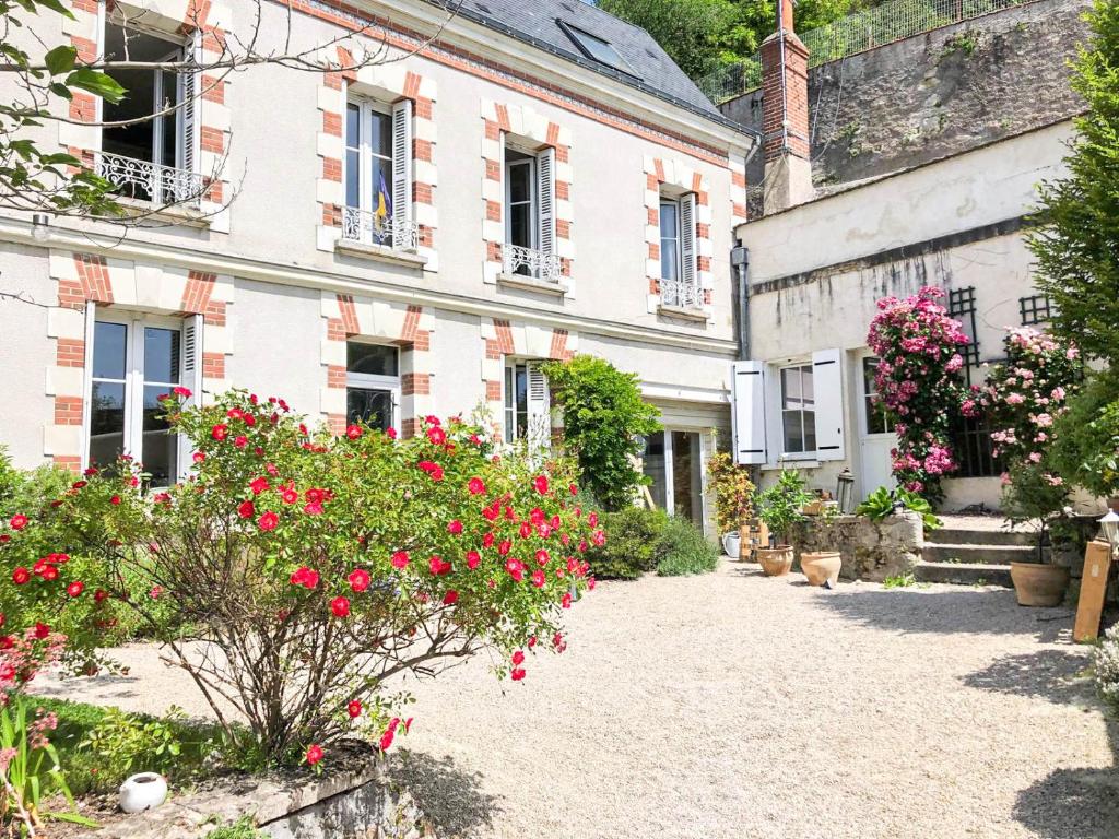 une vieille maison avec des fleurs devant elle dans l'établissement Les Troglos de la Tufolière, à Rochecorbon