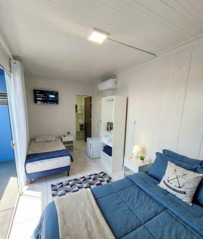 a bedroom with a bed and a bed and a mirror at WaveBox Suítes Container - Enseada in São Francisco do Sul