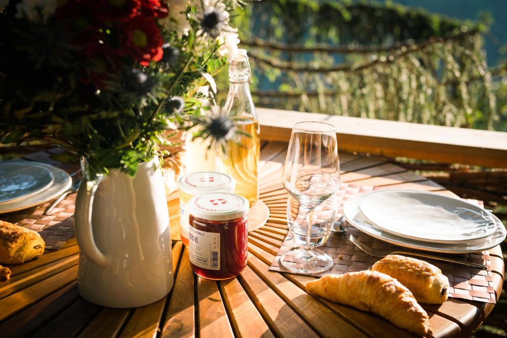 a table with plates and glasses and bread on it at Cabane entre terre et ciel in Saint-Nicolas-la-Chapelle