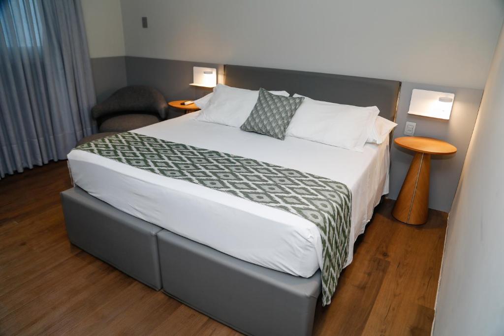 a bedroom with a bed and a chair at Sandri City Hotel in Balneário Camboriú