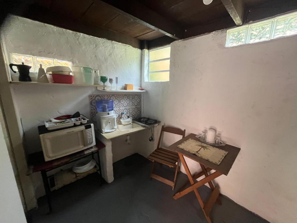 een kleine keuken met een tafel en een magnetron bij Cabana Bacana in São Sebastião