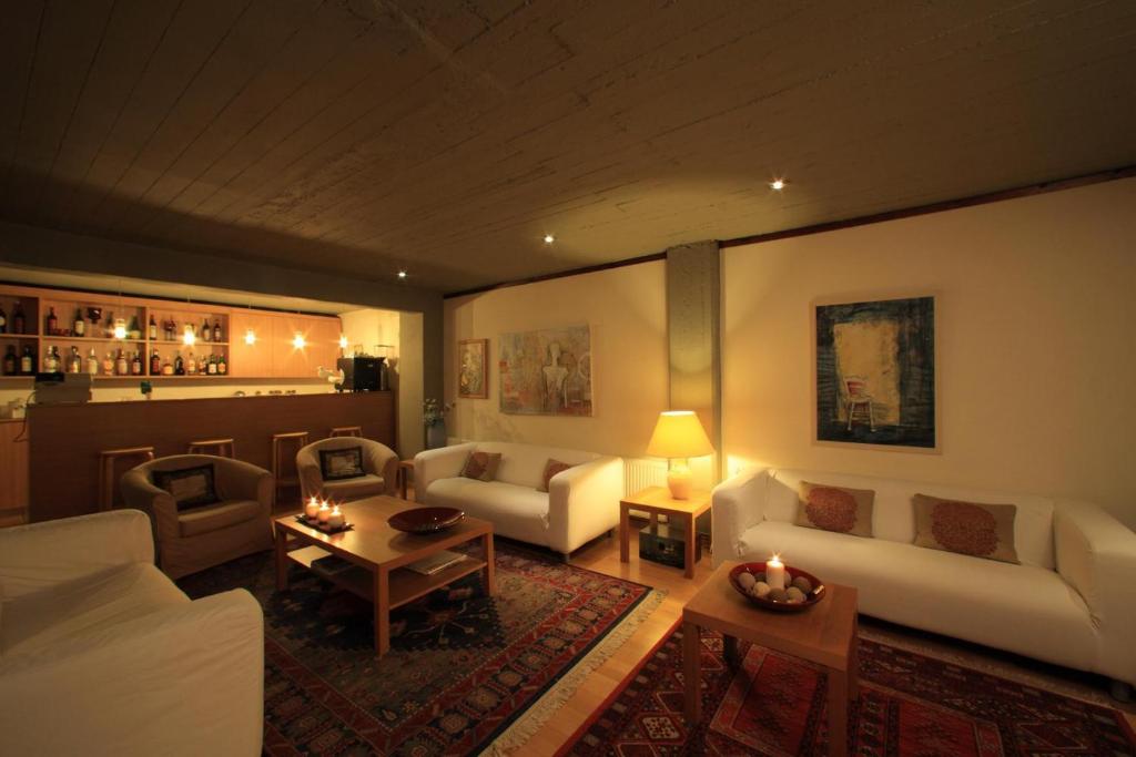 a living room with white couches and a table at Dioscouri Hotel in Sparta