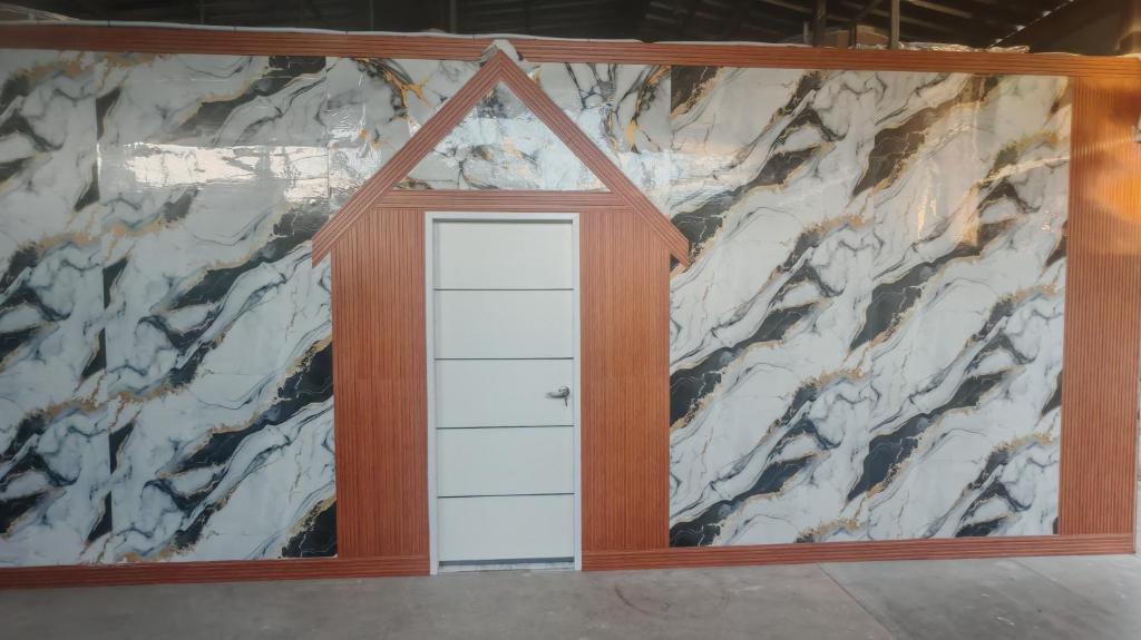 una stanza con una porta bianca di fronte a un muro di marmo di Country House a Ban Nong Chaeng