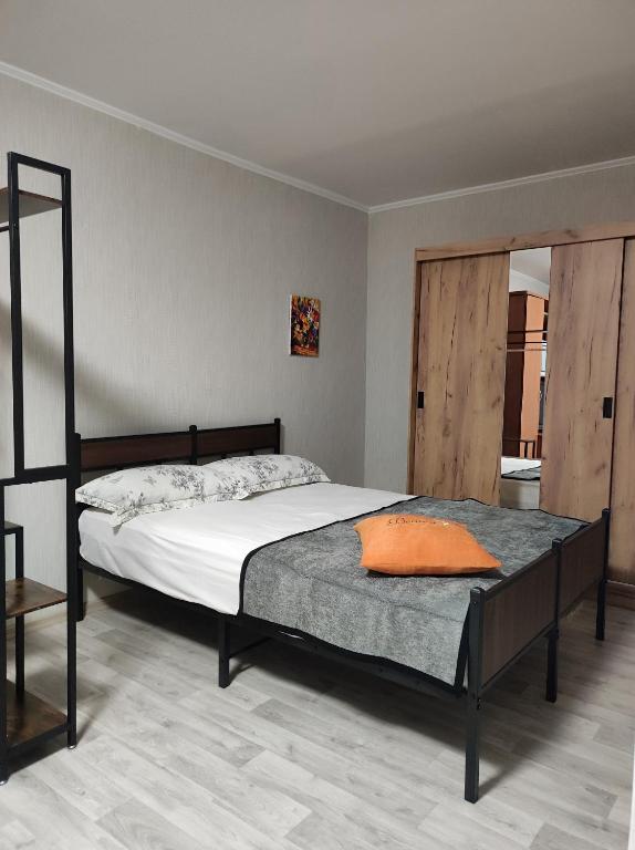 a bedroom with a bed with an orange pillow on it at Laima in Riga