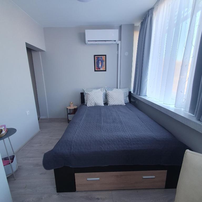 a bedroom with a bed with a blue comforter at Yantra Tower Studio Maya in Gabrovo
