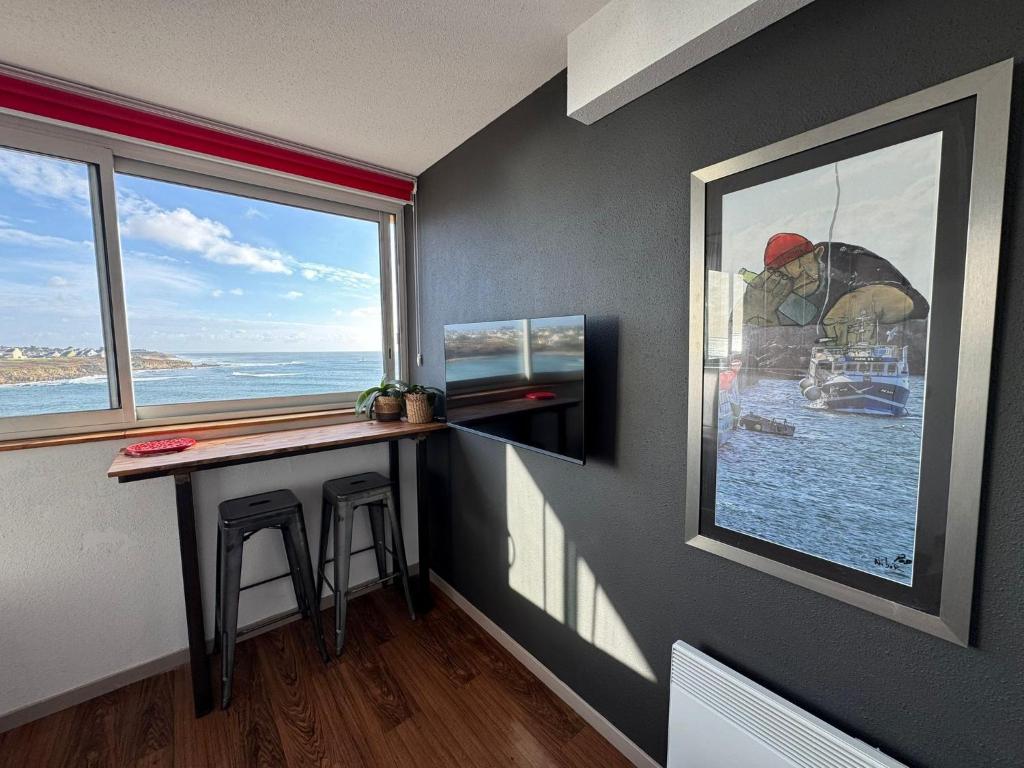 una stanza con un tavolo e una grande finestra di Appartement duplex vue mer ad Audierne