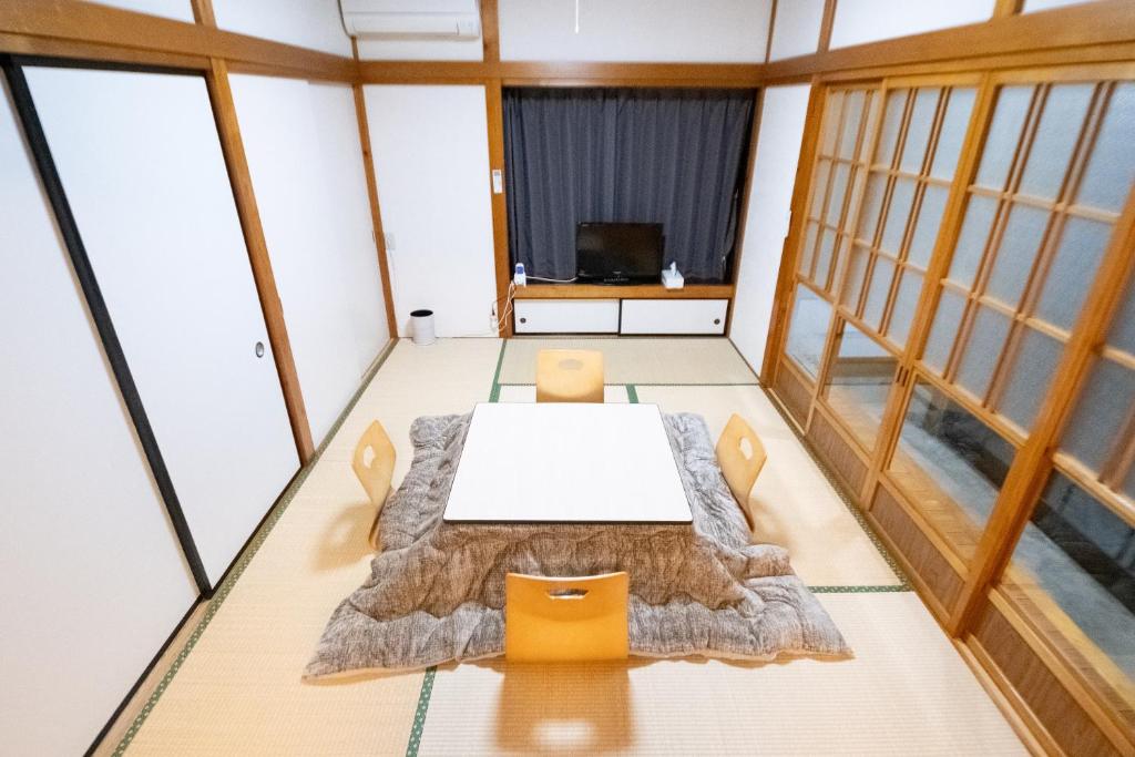 a table and chairs in a room with windows at Oharama House in Nasushiobara