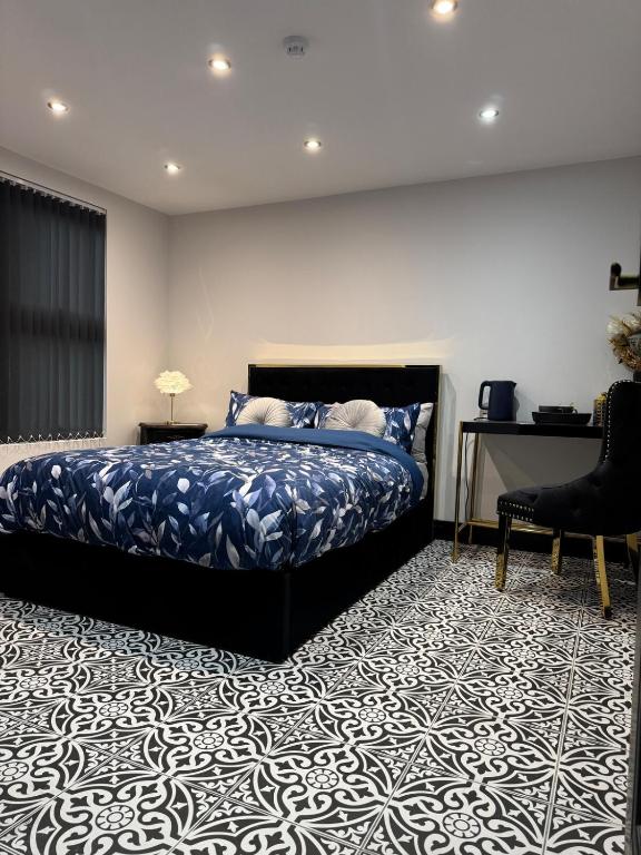 een slaapkamer met een bed, een bureau en een stoel bij Marble Black Deluxe in Gloucestershire