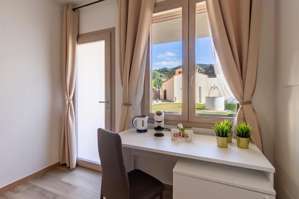 een bureau in een kamer met een raam bij Affittacamere Lumal in Domus de Maria