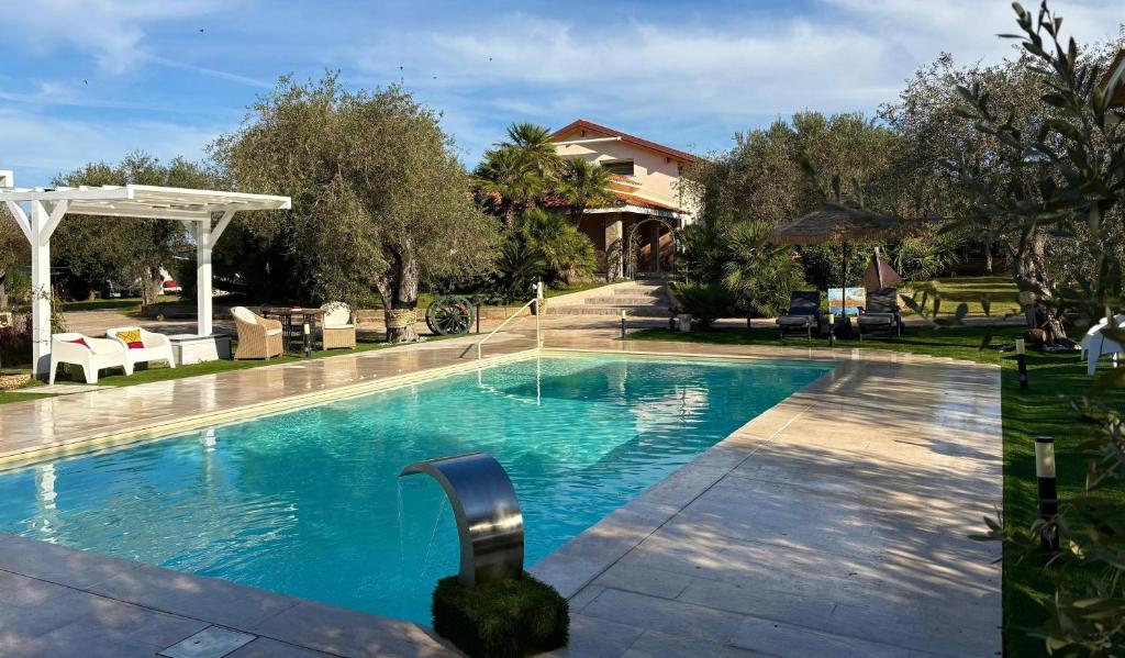 einen Pool mit blauem Wasser vor einem Haus in der Unterkunft Villa Marianna in Alghero