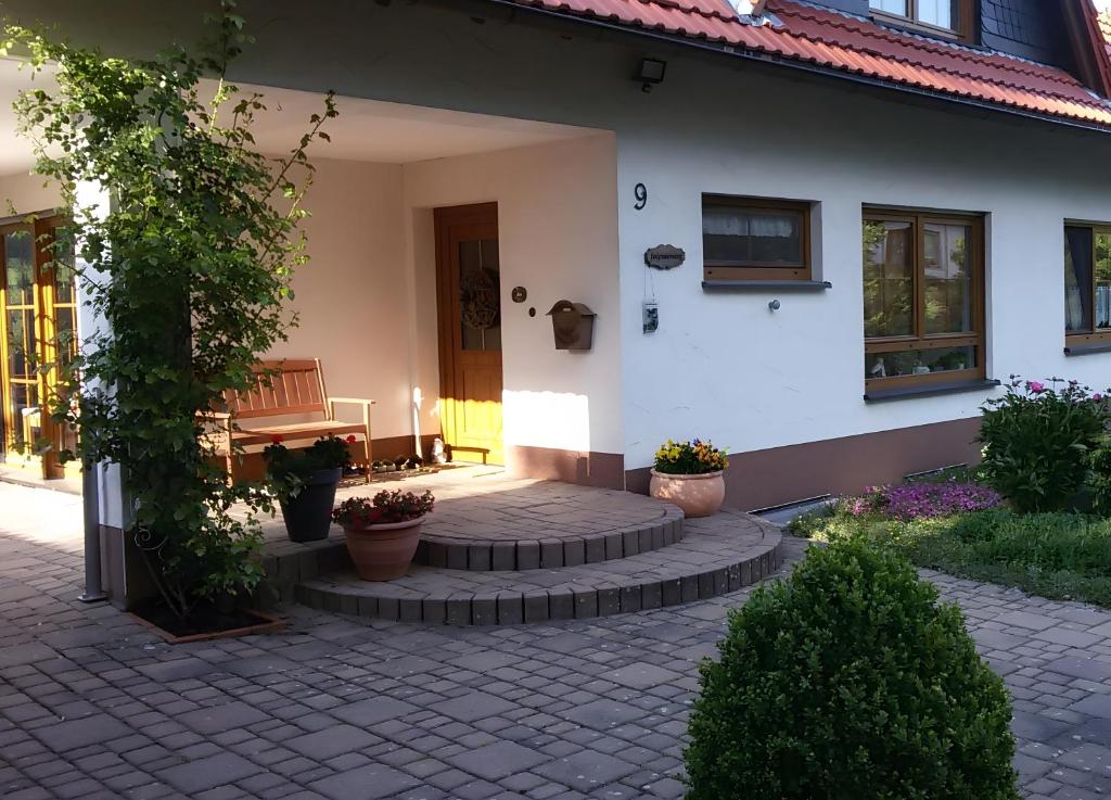 un patio di fronte a una casa bianca con panchina di Ferienwohnung, 55qm a Herscheid
