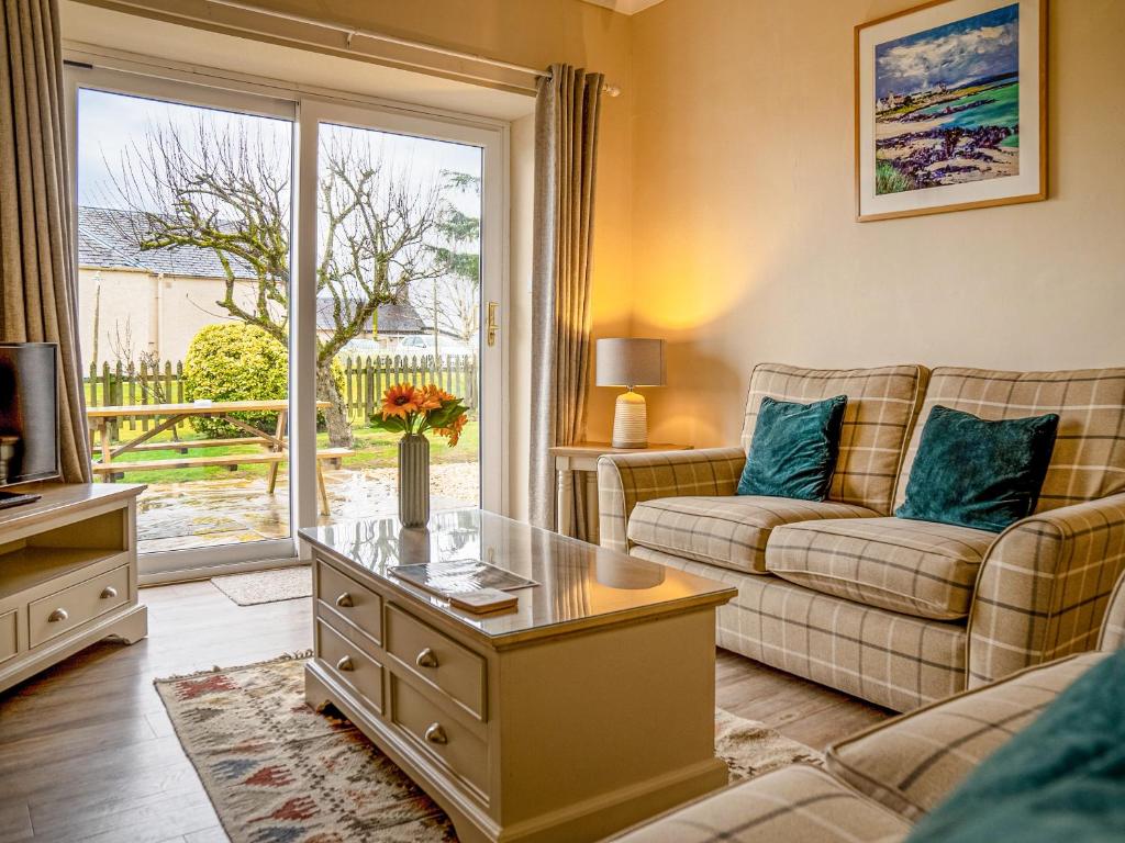 een woonkamer met een bank en een tafel bij Dovecote - Uk47887 in Keilour