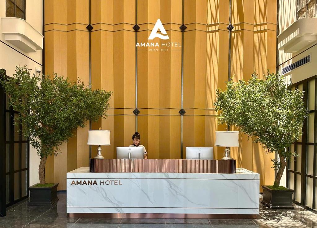 Ấp Bình HưngにあるAMANA Hotel Phan Thietのホテル前の机に座る女性