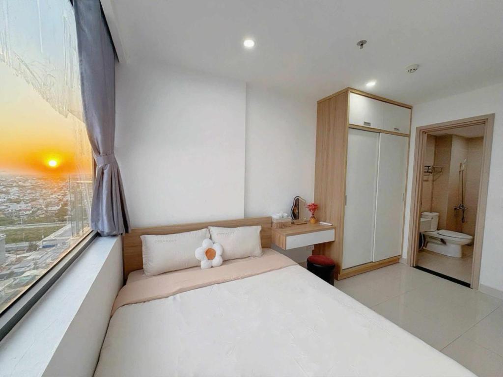 a bedroom with a large bed and a window at Tom's House Apartment 1 in Thôn Văn Dương