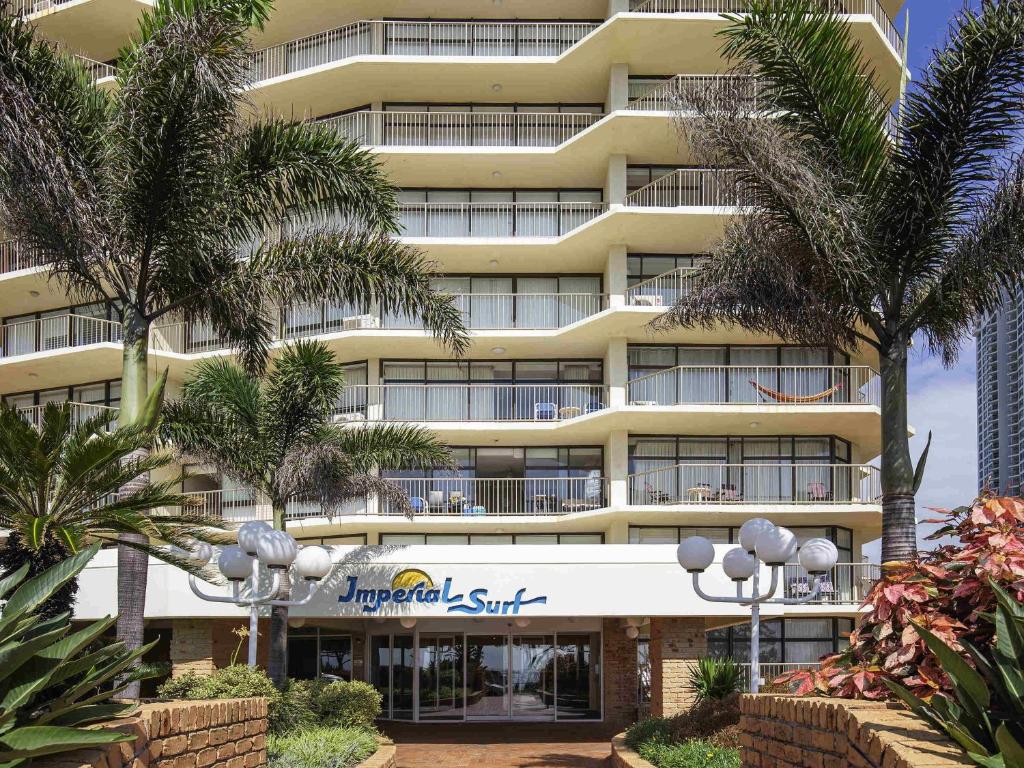 een groot gebouw met palmbomen ervoor bij BreakFree Imperial Surf in Gold Coast