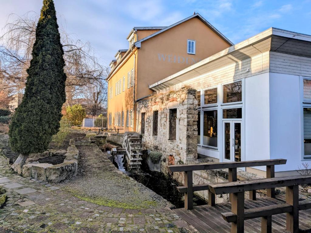 a building with a bench in front of it at Gästehaus Weidenmühle in Mühlhausen