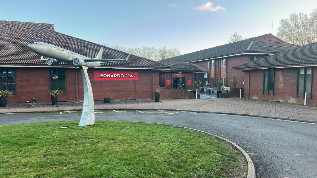 Eine Flugzeugstatue mitten auf einer Straße in der Unterkunft Leonardo Hotel East Midlands Airport in Castle Donington