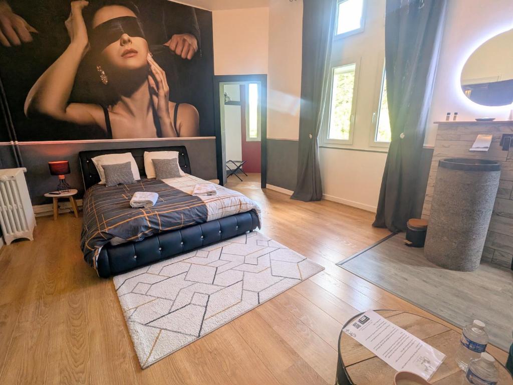 una camera con un letto e un dipinto di una donna di Suite Baccara a Cluis