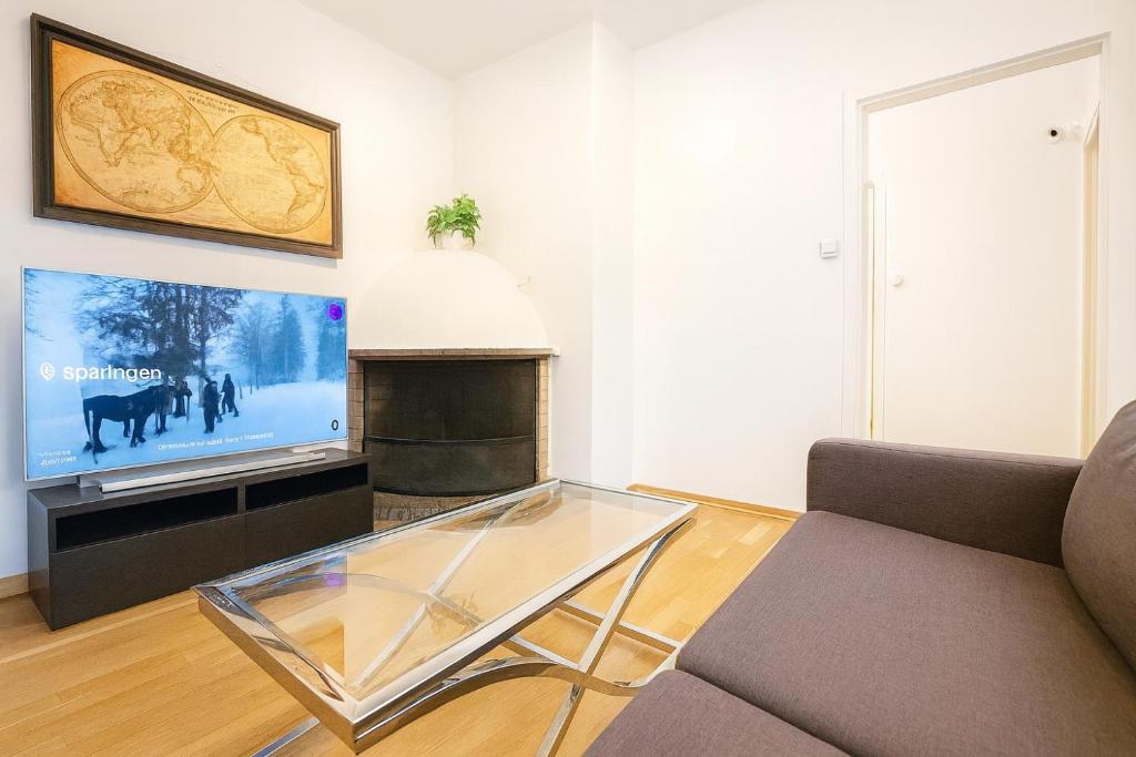ein Wohnzimmer mit Sofa und Flachbildfernseher in der Unterkunft Spaceous room in Majorstuen central Oslo by subway in Oslo