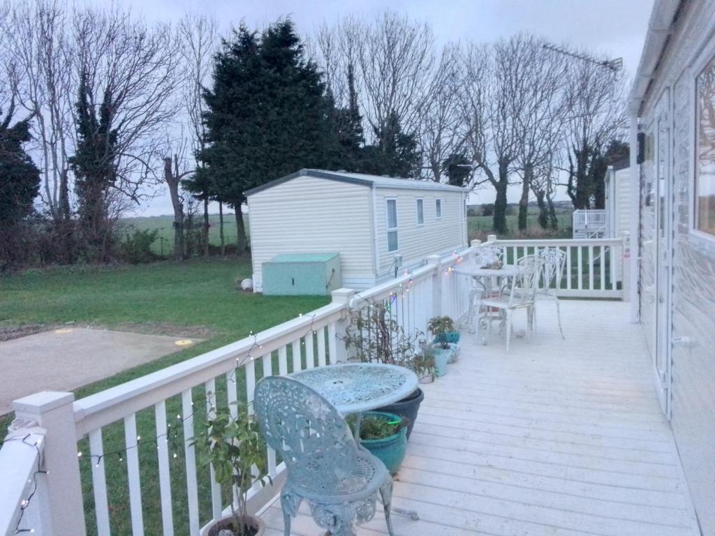 a porch with a table and chairs and a house at Lovely new private caravan situated at park dean resorts ,st margerets at cliffe white cliffs kent in St Margarets at Cliff
