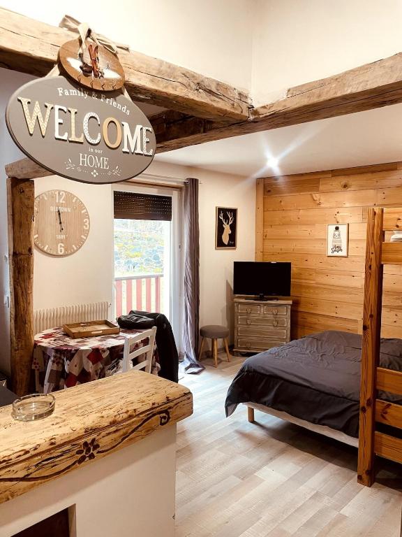 a bedroom with a bed and a sign that reads welcome and home at Studio cosy proximité télécabine ski Meribel - Cure thermale in Brides-les-Bains
