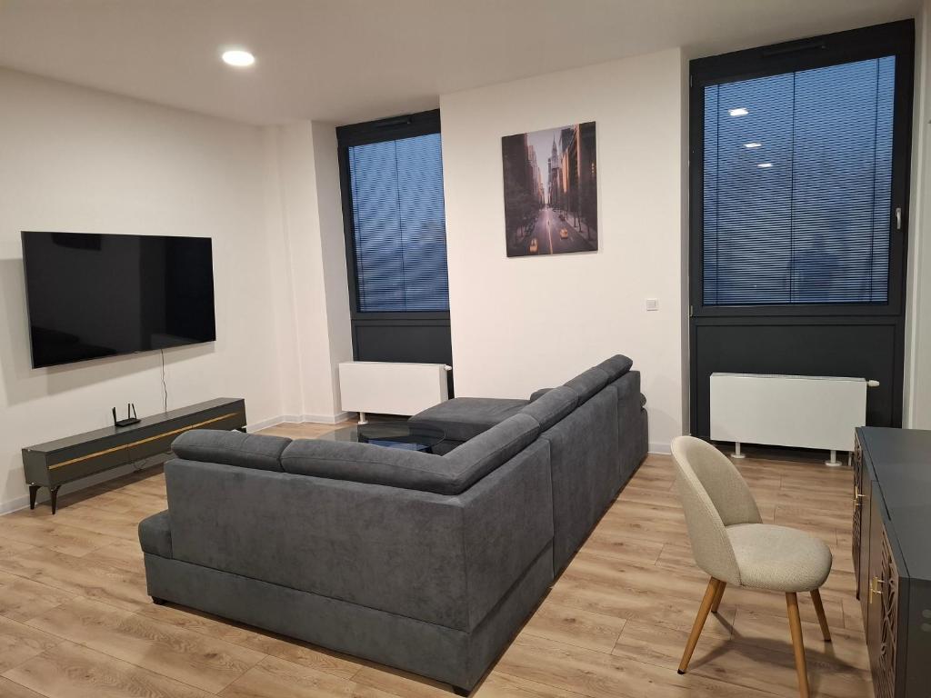 een woonkamer met een bank en een tv bij Apartmán Central Point 1 in Humenné