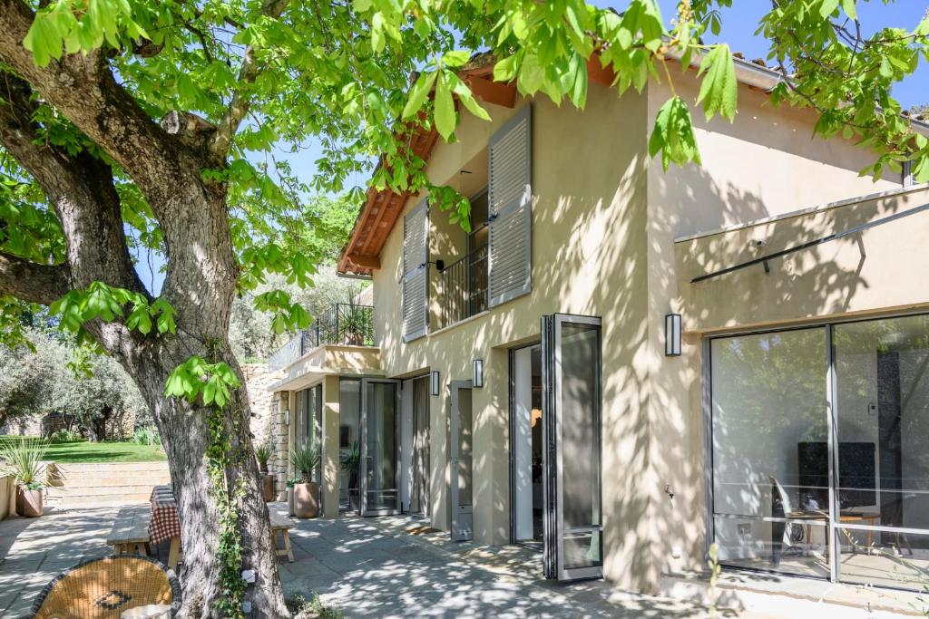ein Haus mit einem Baum davor in der Unterkunft Le Hameau des Sources Lourmarin Luberon in Apt