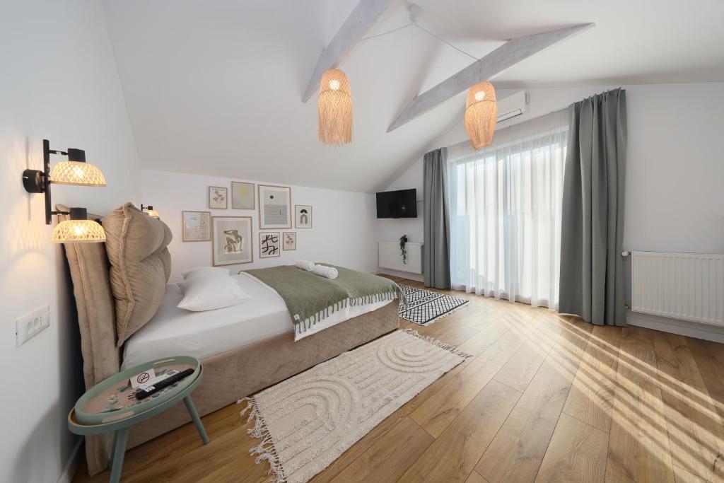 a white bedroom with a large bed and a table at EPIC Vila Brașov, Cristian in Braşov
