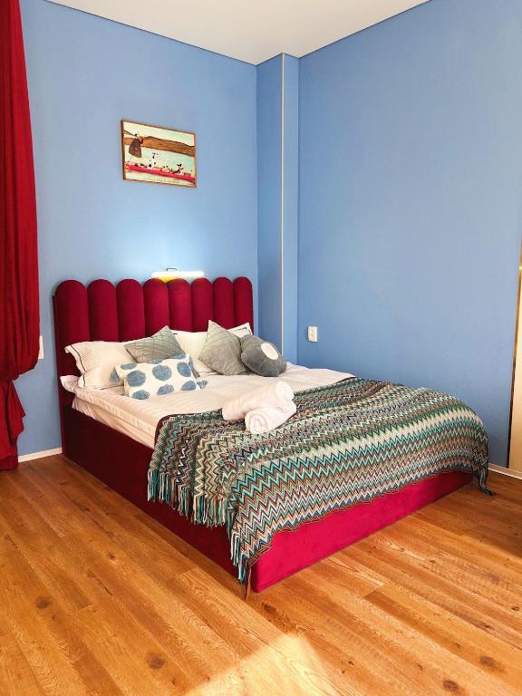 een slaapkamer met een bed met een rood hoofdeinde bij FLAT24 - Red in Zhezdi