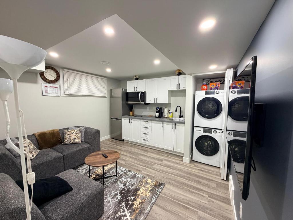 een woonkamer met een bank en een keuken bij 2-Bed Cozy Nest in Winnipeg