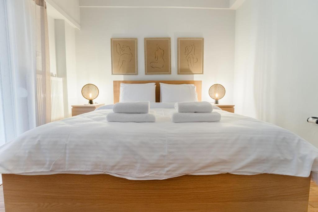 een slaapkamer met een groot wit bed met twee lampen bij Daphnes Home Chalkida Central in Chalkida