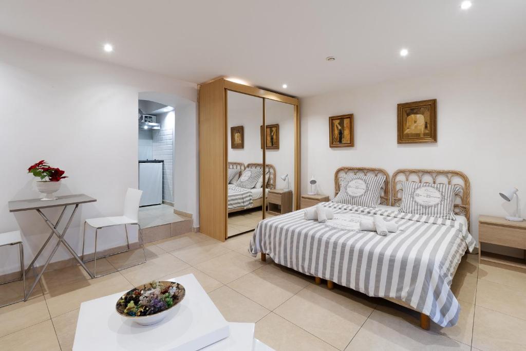 een slaapkamer met een bed met een tafel en een spiegel bij Studio indépendant en villa Calme, Jardins et Piscine à 5 min de la Mer in Nice