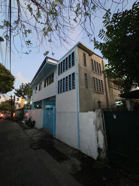 LocsinMamitas Transient的街道上有一栋白色建筑，门是蓝色的。