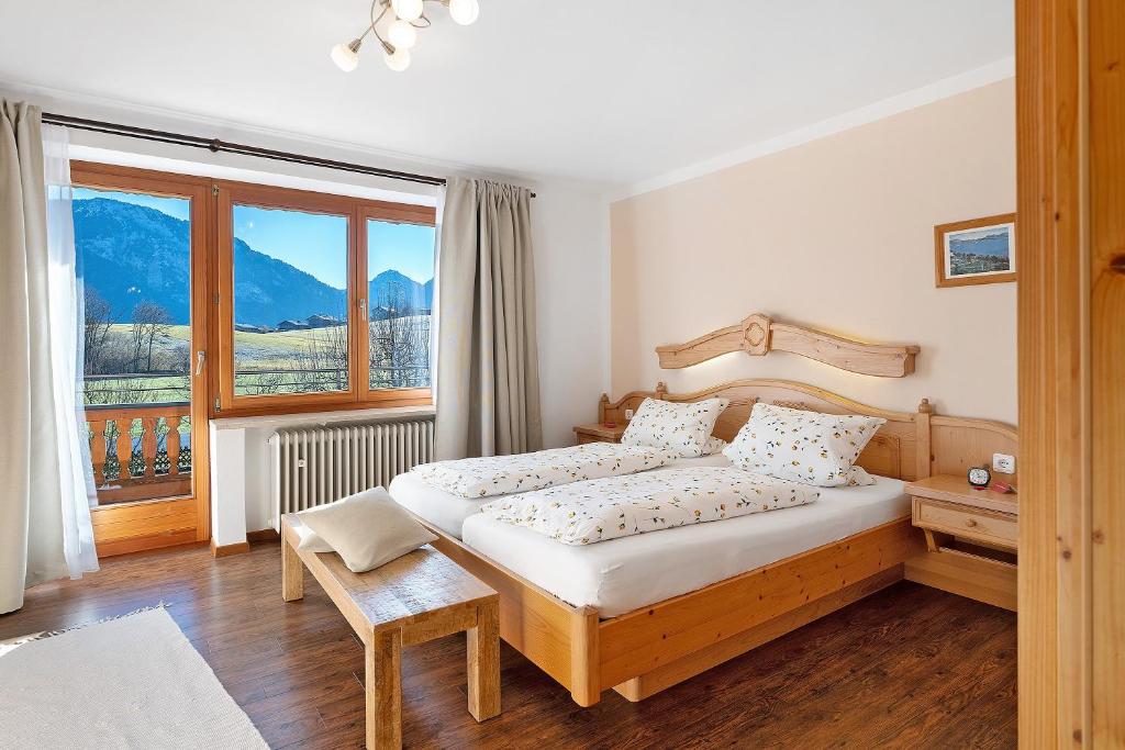 a bedroom with a bed and a large window at Wohnung Hochfelln in Ruhpolding