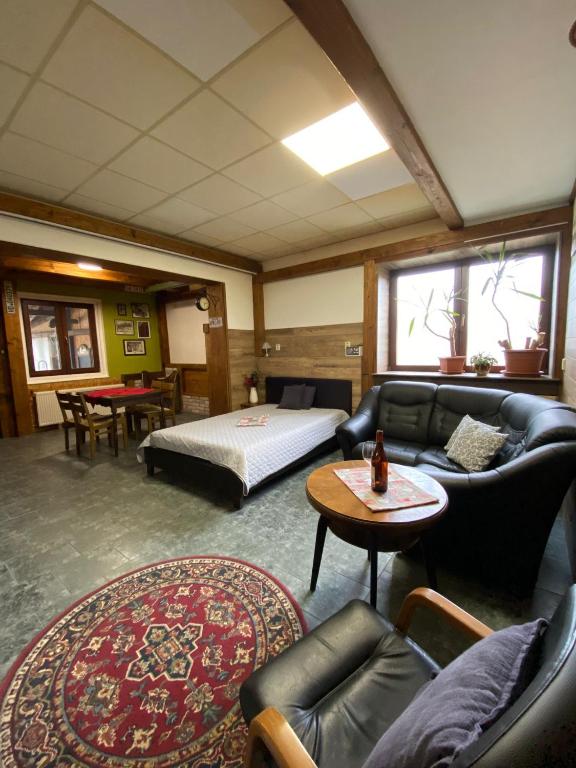 a living room with a couch and a bed at Studio JAVOR pod Tatrami in Jezersko