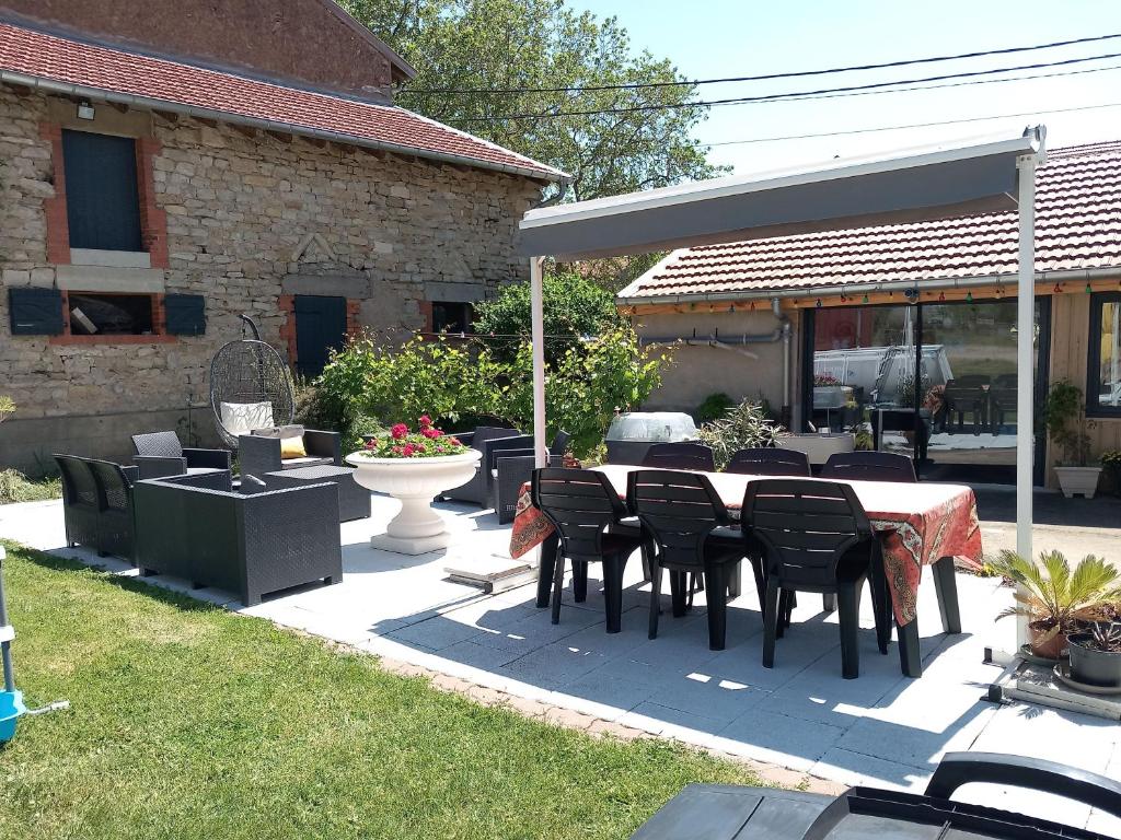 un patio avec une table et des chaises dans une cour dans l'établissement O p'tit nid à bulles, à Létricourt