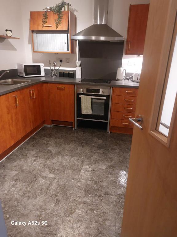 a kitchen with wooden cabinets and a stove top oven at Aphrodite in Birmingham