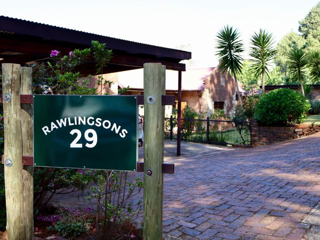 a sign on a post in front of a driveway at Rawlingsons Country House in Dullstroom