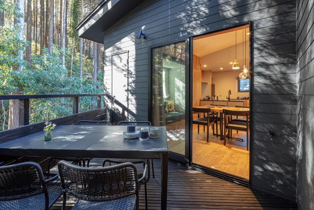 a screened porch with a table and chairs on a deck at Shiki - Hakone- in Hakone