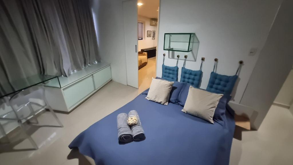 una camera da letto con un letto blu con scarpe sopra di Flat mobiliado e bem localizado a Recife