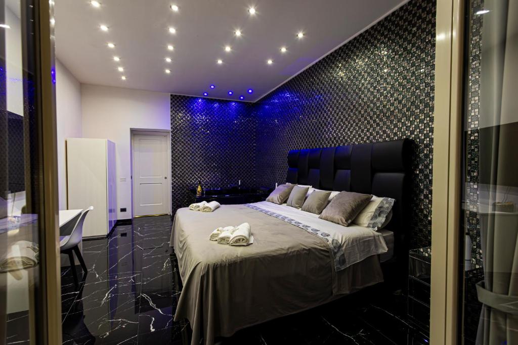 ein Schlafzimmer mit einem großen Bett und violetten Lichtern in der Unterkunft Scio' Scio' in Neapel
