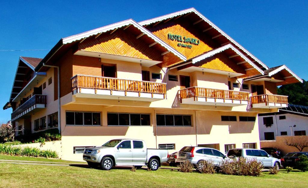 a building with cars parked in front of it at Hotel Sagres in Campos do Jordão