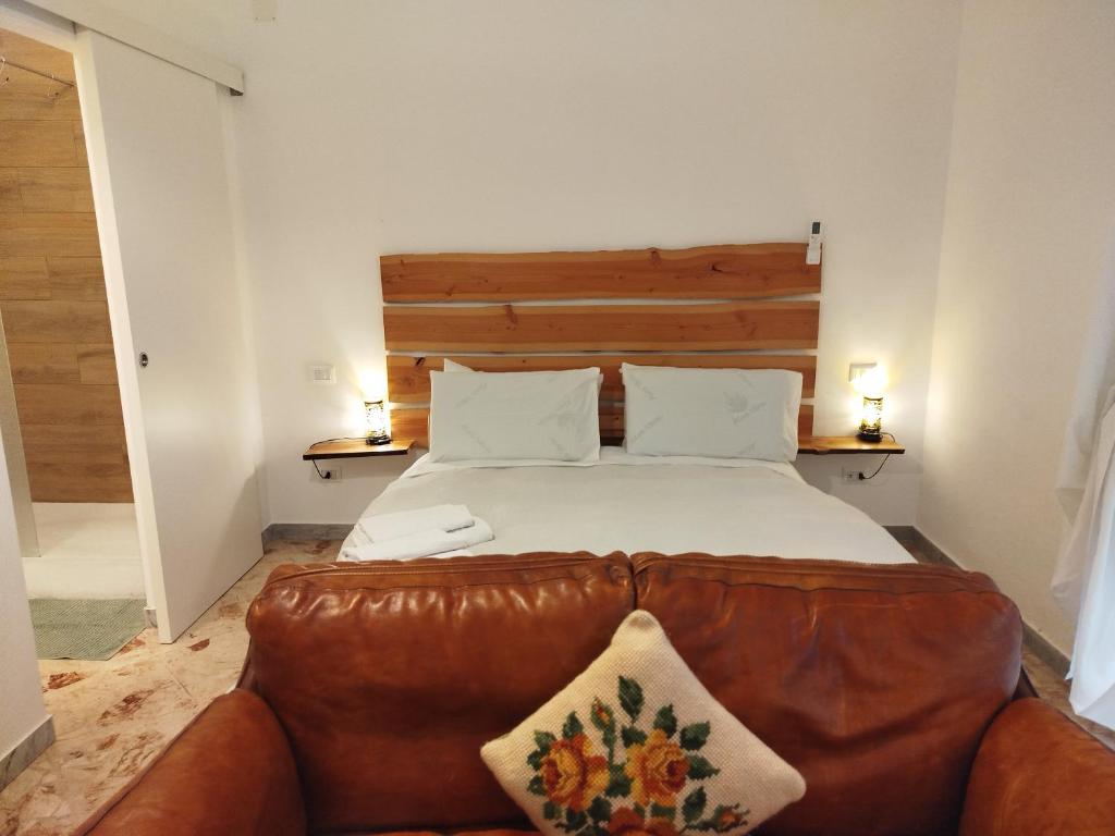 a bedroom with a large bed with a leather couch at CasaRA in Bari