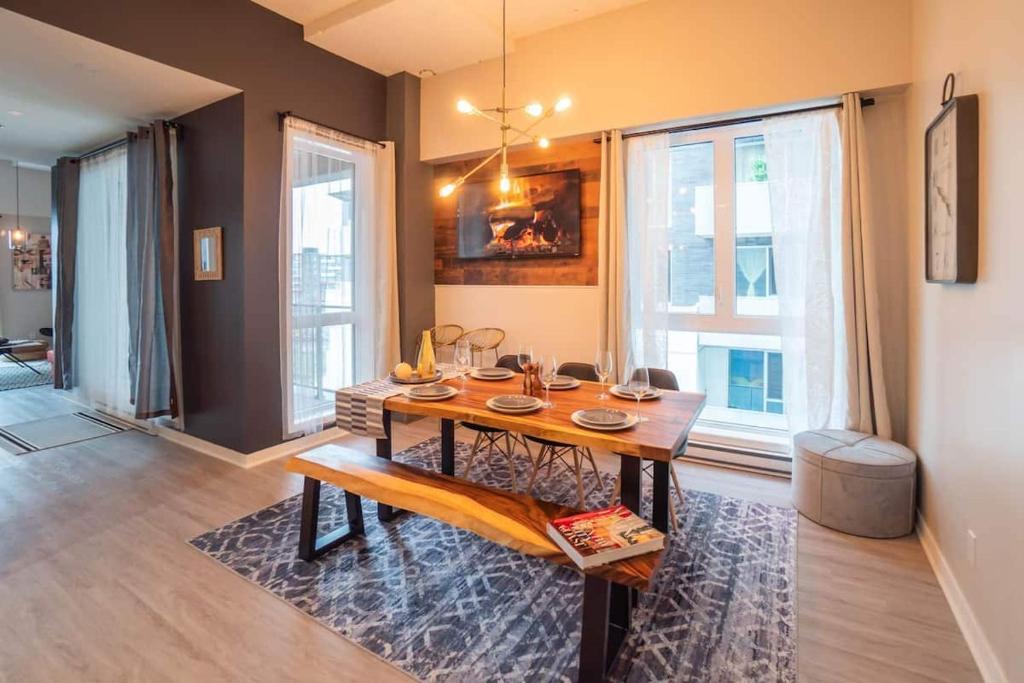 una sala da pranzo con un tavolo e alcune finestre di Buchanan 401 - Midtown Condo Luxe and gym a Montréal