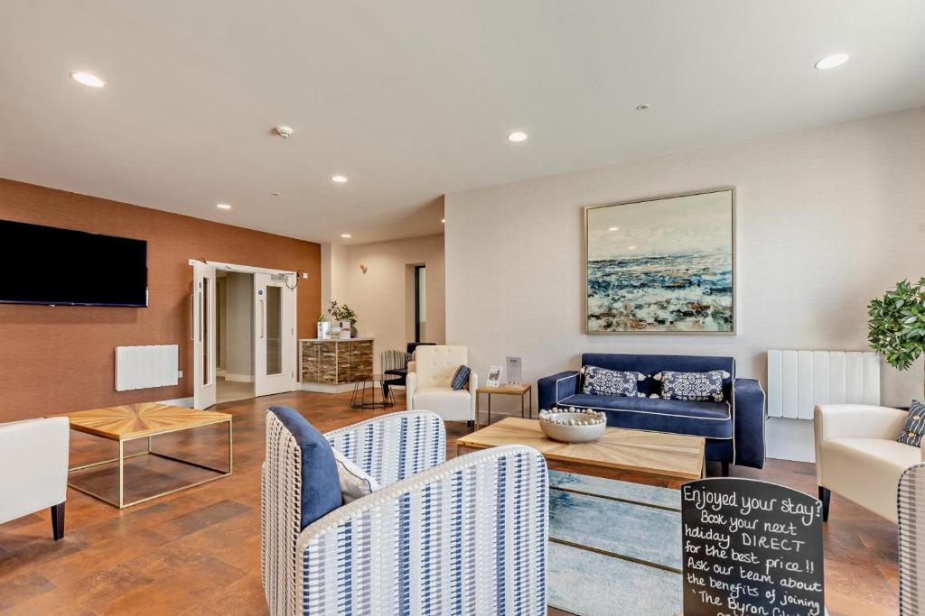 een woonkamer met een blauwe bank en stoelen bij 2 Bed in Woolacombe oc-c27395 in Woolacombe