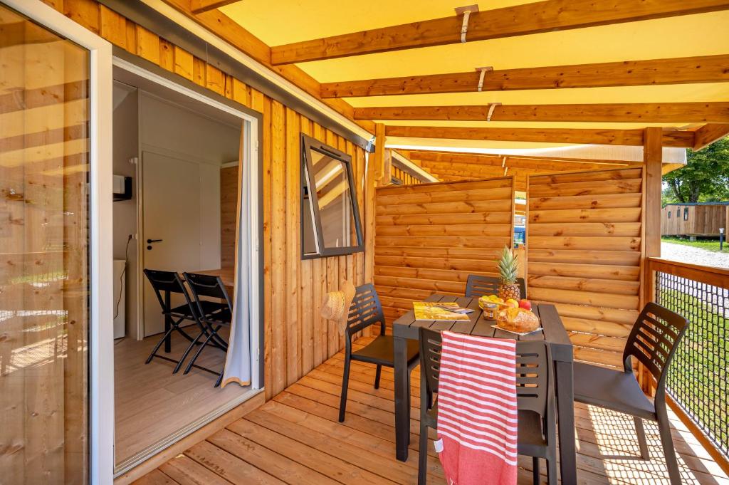 un patio avec une table et des chaises sur une terrasse dans l'établissement Camping Capfun La Bretèche, aux Épesses 27 autres photos